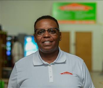 Smiling woman wearing glasses and white SERVPRO shirt