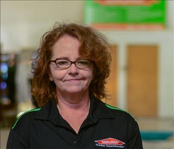 Woman with glasses and curly hair wearing a SERVPRO shirt