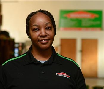 Smiling woman with small earrings wearing SERVPRO shirt