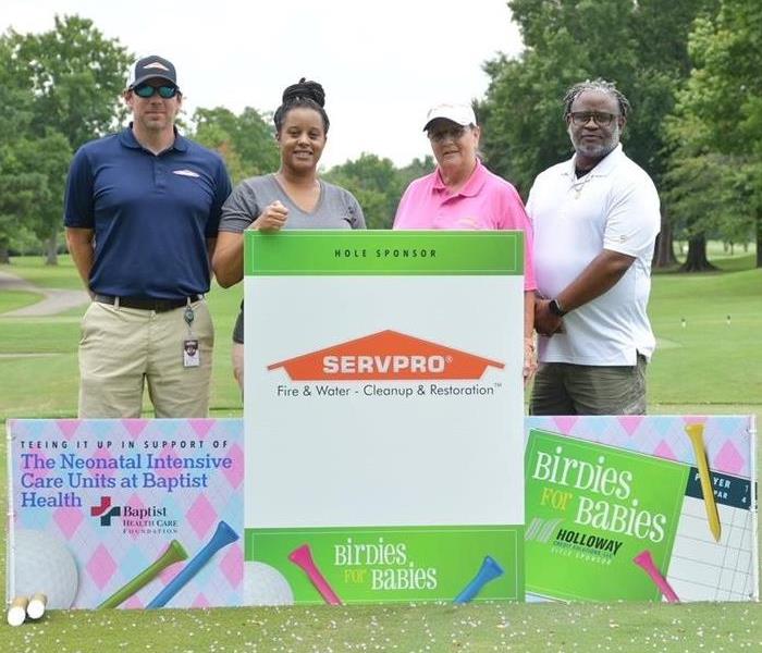 marketing team holding signs for golf tournament