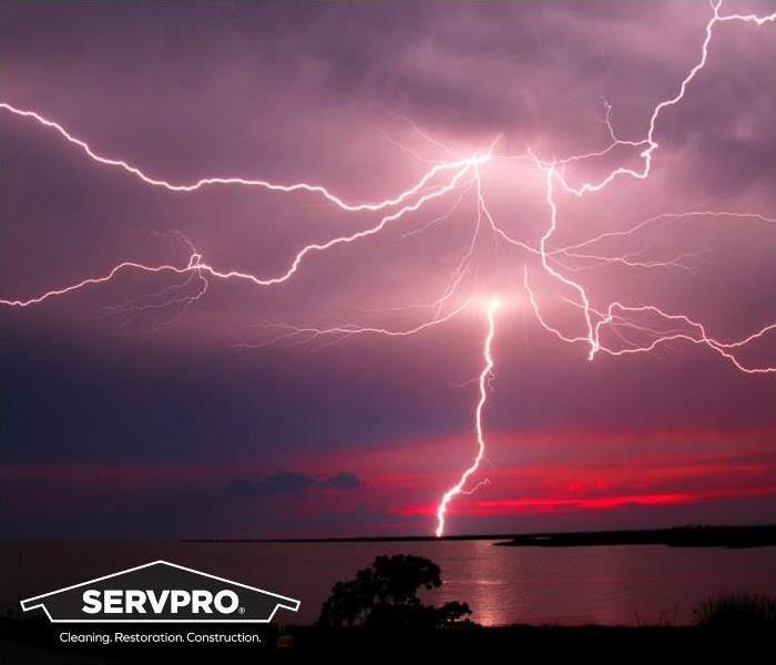  lightning strike across sky over water with SERVPRO logo 